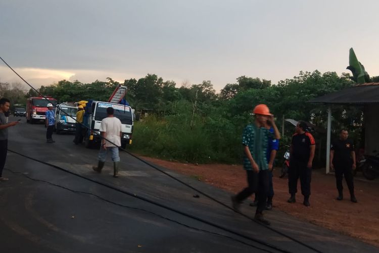 Kabel listrik melintang jalan dari tiang yang roboh di Desa Pemali, Bangka, Kepulauan Bangka Belitung, Jumat (3/5/2019).