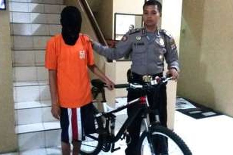 Oscar Dela Hoya Hasibuan saat berada di Mapolsek Bulaksumur bersama barang bukti sepeda yang di curinya
