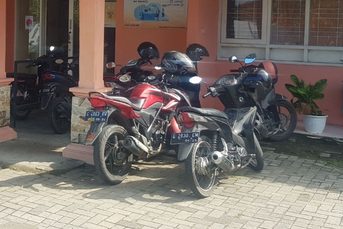 Suasana tempat parkir motor, banyak ditemukan helm menggantung di spion