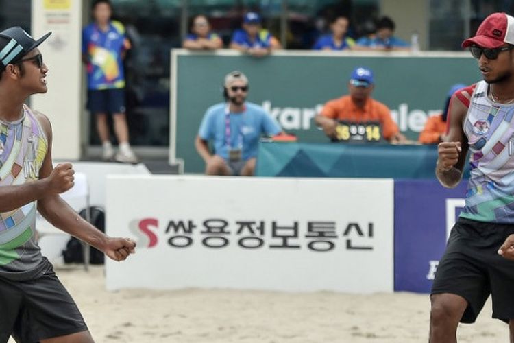 Pebola voli pantai putra Indonesia Mohammad Ashfiya (kiri)/Ade Candra Rachmawan (kanan) melakukan selebrasi seusai berhasil mengembalikan bola ke arah pevoli Cina pada pertandingan babak perempatfinal voli pantai putra Asian Games 2018 di arena Jakabaring Sport City, Palembang, Sumsel, Sabtu (25/8/2018),