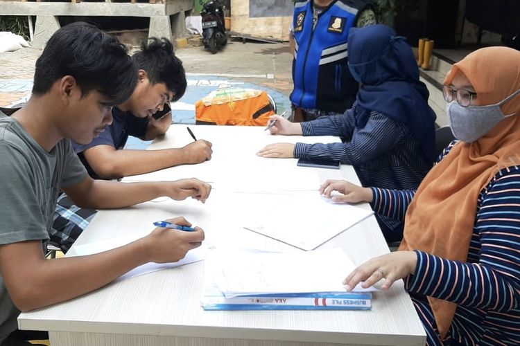 Petugas mendata warga yang tak menggunakan masker saat terjaring razia masker di Kelurahan Lenteng Agung, Jagakarsa, Jakarta, (16/8/2020) pagi.