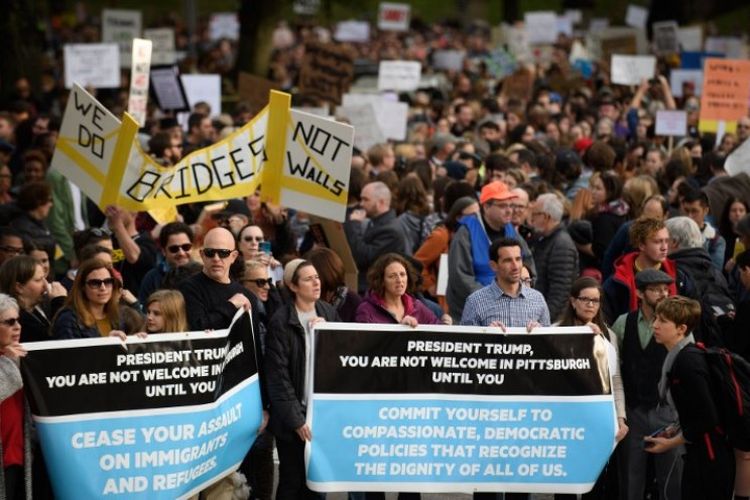 Sekitar 4.000 orang berunjuk rasa dan melakukan aksi solidaritas di lingkungan perumahan Squirrel Hill sementara Presiden Amerika Serikat Donald Trump berkunjung ke sinagoge, lokasi penembakan massal, di Pittsburgh, Pennsylvania, Selasa (30/10/2018). (AFP/Jeff Swensen)