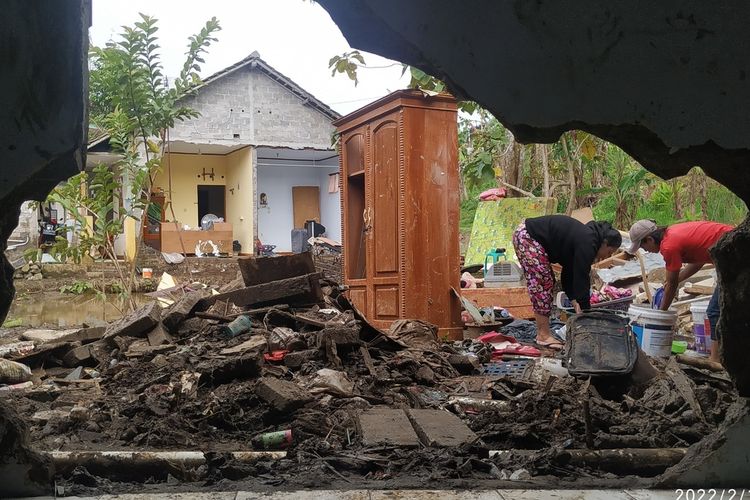 Dua penyintas bencana mencuci pakaian tersisa yang kotor terendam banjir luapan sungai Cisuda di Kampung Tugu, Kelurahan Jaya Raksa, Baros, Sukabumi, Jawa Barat, Jumat (18/2/2022).