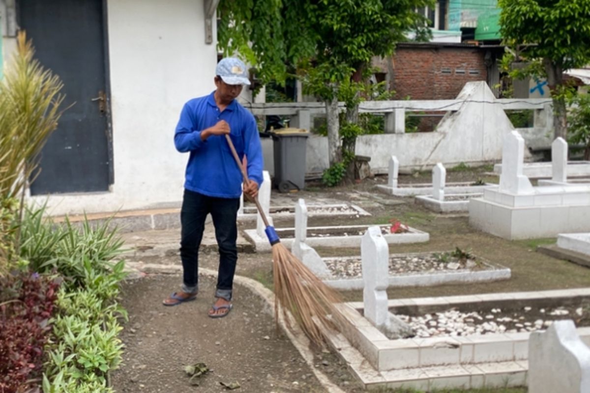 Safiin, saat membersihkan TMP Ngagel, Surabaya, Senin (17/11/2025).