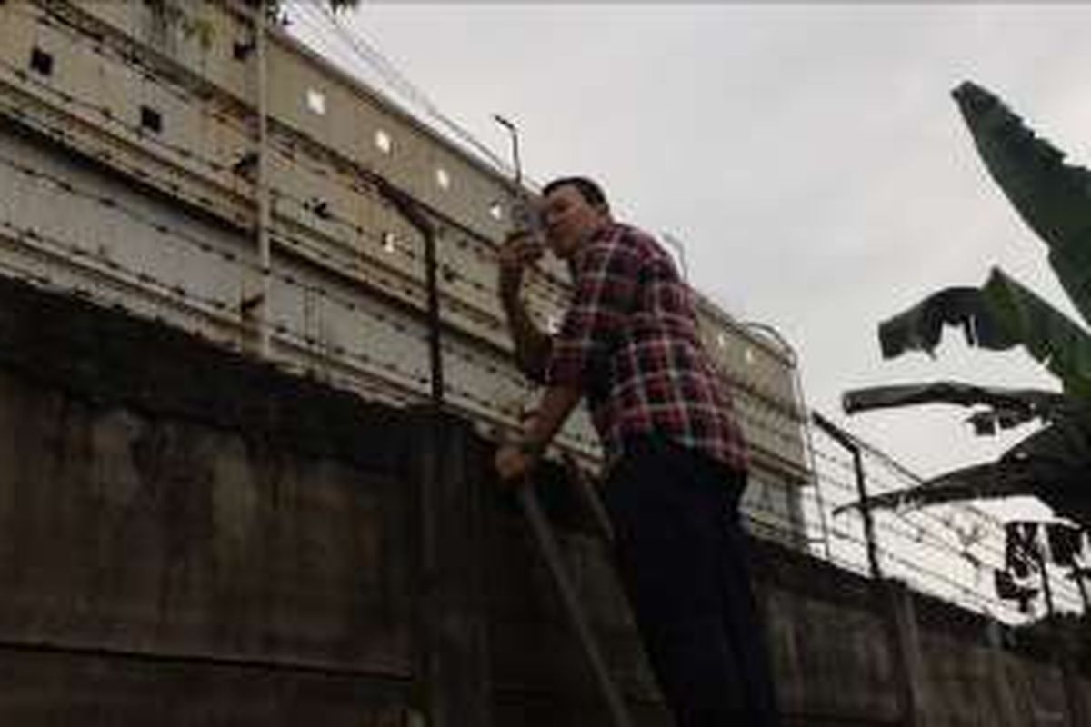 Calon gubernur DKI Jakarta petahana, Basuki Tjahaja Purnama atau Ahok memanjat pagar tembok di kali RT 07/07, Kebagusan, Jakarta Selatan, Kamis (1/12/2016).