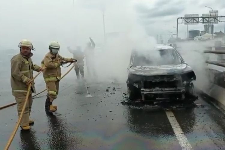 Sebuah mobil Suzuki Ertiga bernomor polisi B 2683 KZF hangus terbakar di Jalan Tol Wiyoto Wiyono, wilayah Cipinang Cempedak, Jatinegara, Jakarta Timur, Senin (29/11/2021).