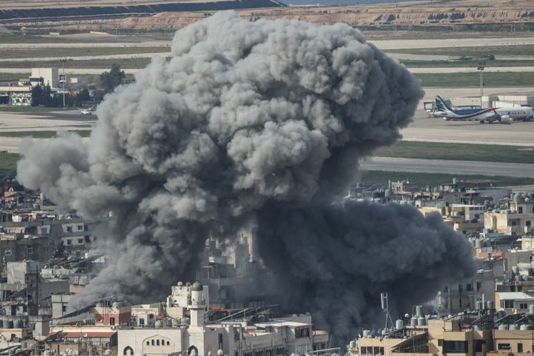 Asap mengepul dari lokasi serangan udara Israel yang menargetkan lingkungan Al Lailaki di pinggiran selatan Beirut, dengan bandara internasional kota terlihat di latar belakang, pada 4 Maret 2026.