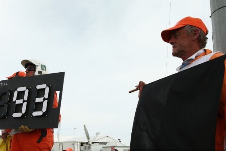 Petugas membentangkan bendera hitam atau black flag untuk Marc Marquez (Repsol Honda) pada gelaran MotoGP Australia, 20 Oktober 2013.