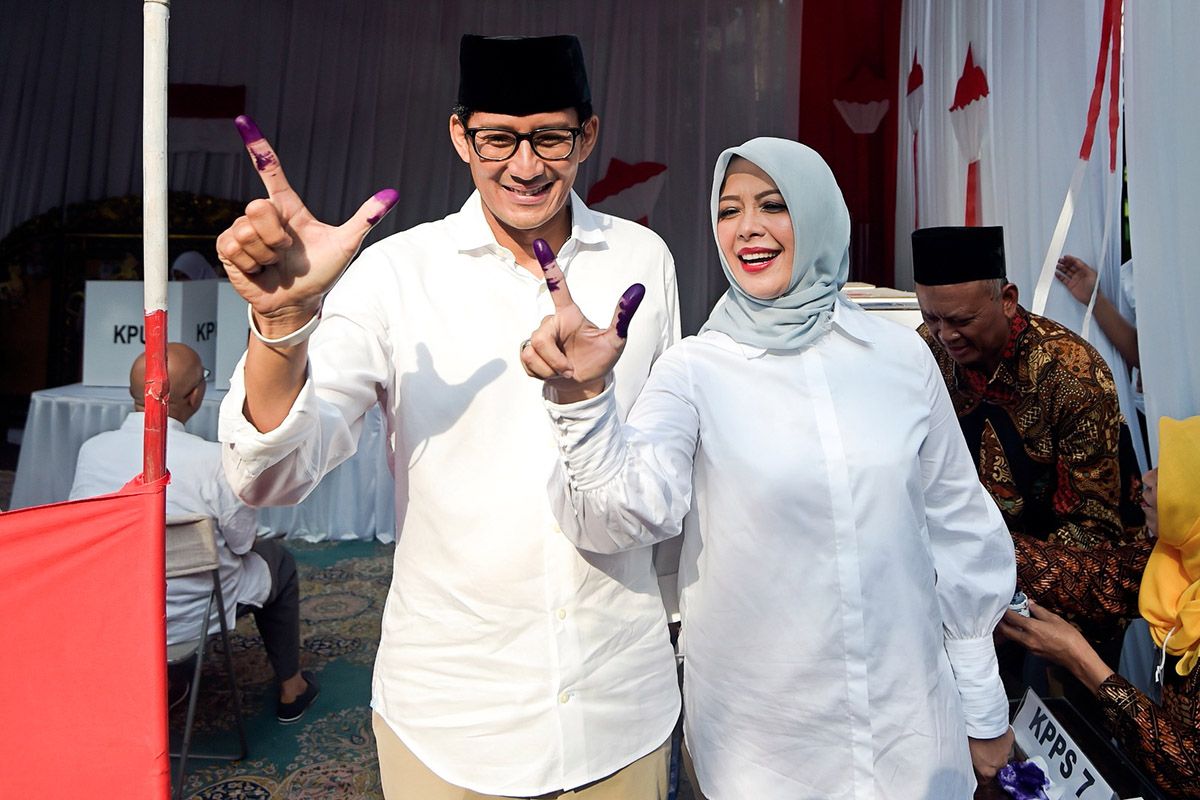 Calon wakil presiden nomor urut 02 Sandiaga Uno (kiri) dan istri Nur Asia Uno (kanan menunjukkan jari yang telah dicelup tinta usai melakukan pencoblosan dalam Pemilu 2019 di TPS 02, Jakarta, Rabu (17/4/2019). Sandiaga tiba di TPS sekitar pukul 07.30 Wib dengan didampingi oleh istri dan kedua anaknya, Anneesha Atheera Uno dan Amyra Atheefa Uno.