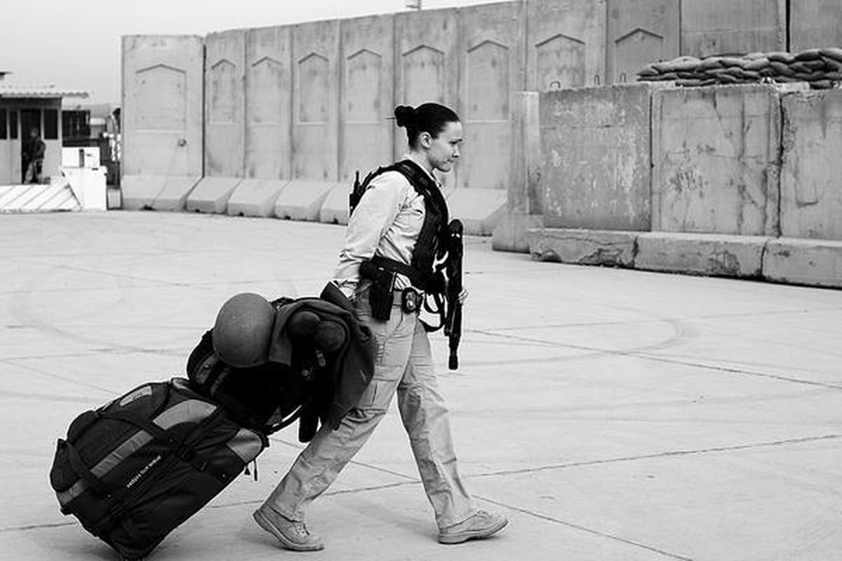 Seorang  petugas keamanan sewaan Amerika Serikat di Irak membawa tas dalam perjalanan pulang ke AS dari Baghdad, Irak, Kamis (15/12). 