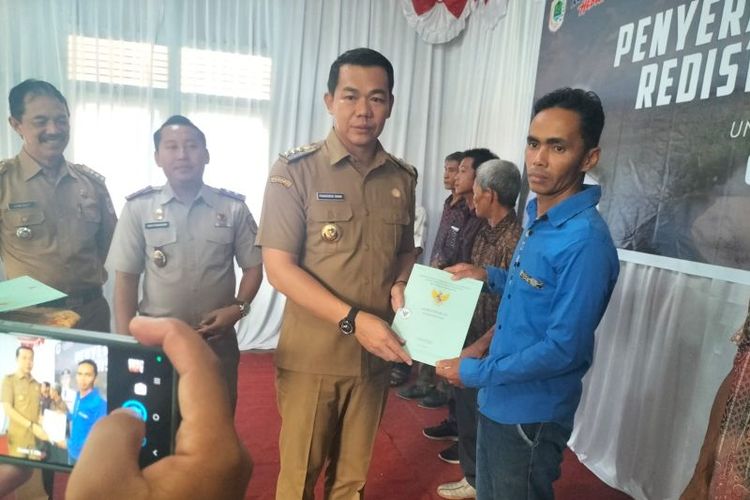 Bupati Kapuas Hulu Fransiskus Diaan menyerahkan sertifikat tanah secara simbolis kepada masyarakat Desa Kedamin Hulu, Kecamatan Putussibau Selatan, wilayah Kapuas Hulu, Kalimantan Barat.