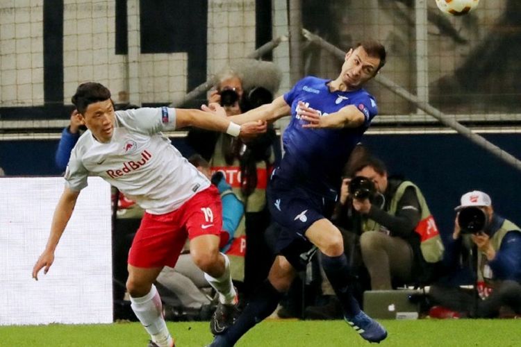 Penyerang Red Bull Salzburg, Hwang Hee-chan Hwang (kiri) berduel memperebutkan bola dengan bek Lazio Stefan Radu pada pertandingan perempat final Liga Europa di Red Buill Arena, 12 April 2018. 