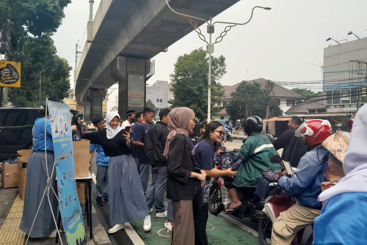 Guru dan murid SMA Cendrawasih 1, Jakarta Selatan berbagi takjil di Jalan Raya RS Fatmawati 