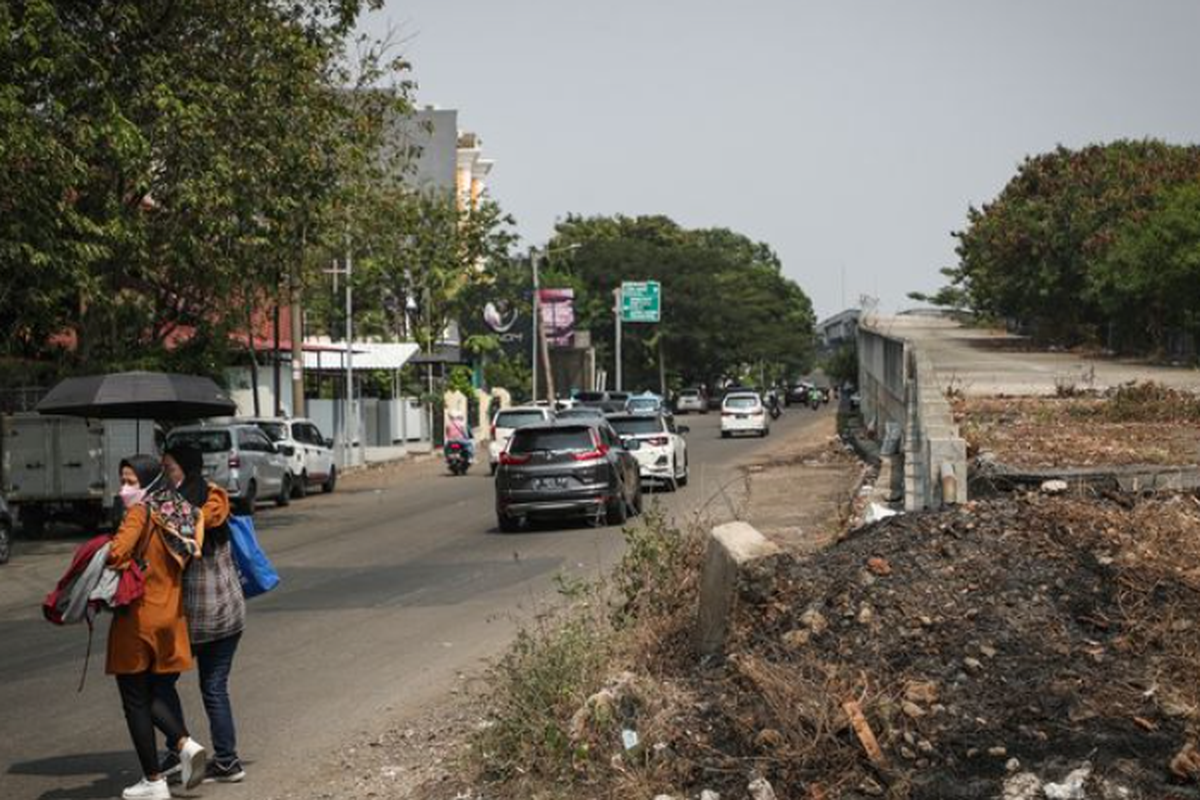 Warga menyeberang jalan di sekitar proyek Jalan Layang Non Tol (JLNT) Pluit, Jakarta Utara, Jumat (2/6/2023).