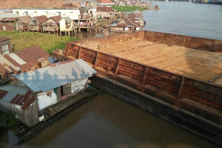 Kapal tongkang BB 01 menghantam salah satu rumah rakit milik warga dan tiang jembatan Ogan Lama saat melintas di perairan sungai Musi.