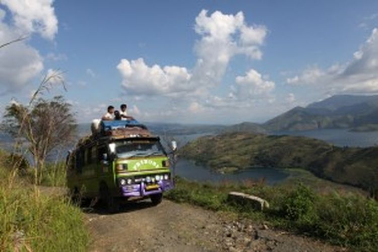 Ilustrasi: Satu angkutan umum menanjak di satu bukit dengan pemandangan Danau Toba menuju perkampungan penduduk di Peabang, Kecamatan Harian Boho, Kabupaten Samosir, Sumut. 