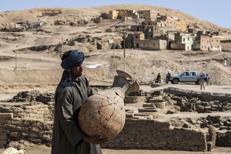 A photo dated April 10, 2021, shows a worker carrying a pot found in the golden city of Egyptian Pharaoh.  The city nicknamed The Rise of Aten was founded during the reign of Amenhotep III and disappeared 3,000 years ago.