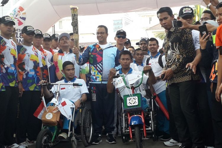 Gubernur DKI Jakarta Anies Baswedan membawa obor Asian Para Games 2018 di depan Balaikota DKI Jakarta, Minggu (30/9/2018).