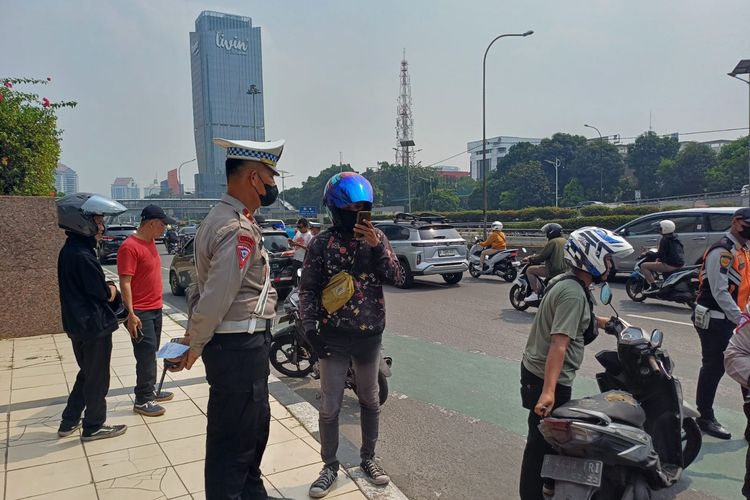 Agus (jaket hitam), saat berbicara dengan Panit 5 Turjawali Satlantas Polres Jakbar Ipda Elvis karena tak terima ditilang 