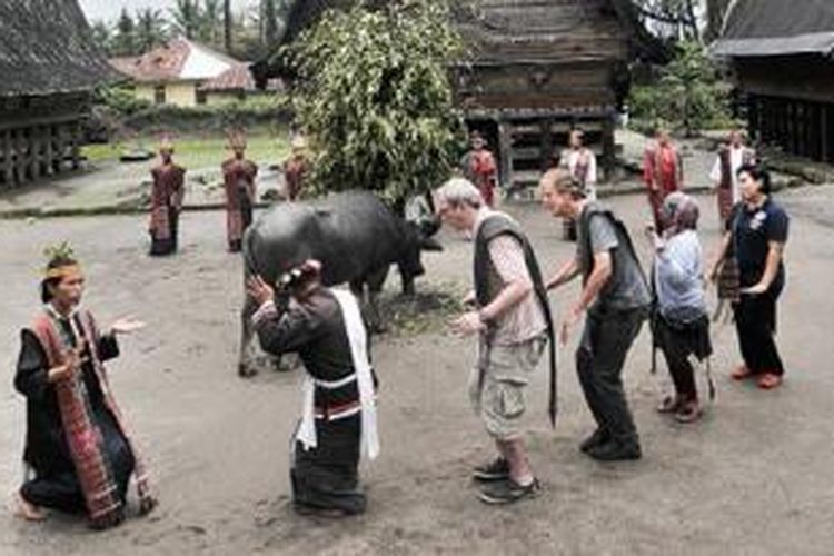 Para pelancong asing diajak menari tortor di pelataran Museum Hutabolon Simannindo, Kabupaten Samosir, Sumatera Utara, Minggu (1/9/2013). Ini merupakan salah satu cara untuk mengenalkan budaya dan tradisi khas Batak Toba kepada dunia luar.