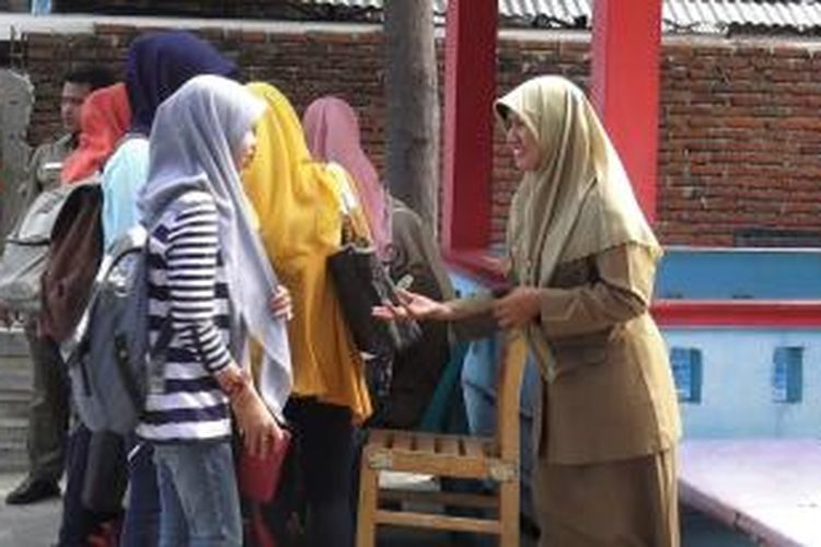 Seorang petugas polisi syariah memberi arahan pada remaja yang kedapatan tidak menggunakan pakaian yang seusai dengan aturan syariat islam, saat razia di kawasan Kota banda Aceh, Rabu (11/6/2014). Puluhan pengguna jalan terjaring dalam razia oleh petugas syariat islam tersebut.