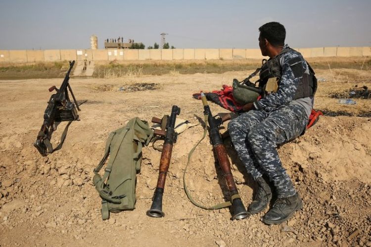 Seorang prajurit Irak beristirahat di bantaran sungai tak jauh dari posisi pasukan Peshmerga Kurdi yang berada di kota Kirkuk.