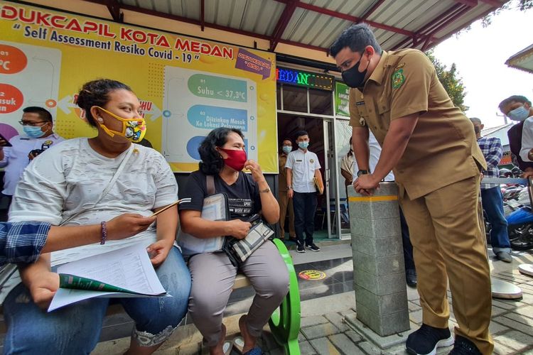 Wali Kota Medan, Bobby Nasution berinteraksi dengan warga yang mengadu kepadanya soal bantuan PKH yang tak kunjung cair, di sela-sela sidak di Disdukcapil Kota Medan, Senin (17/5/2021).