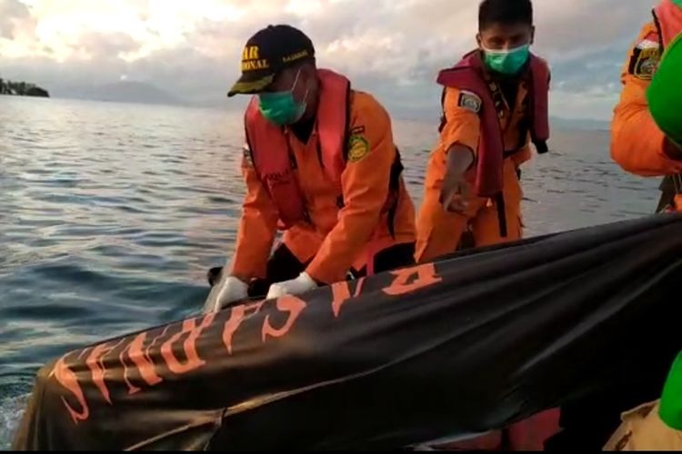 Petugas dari Kantor Basarnas Kendari mengangkat kantong jenazah korban KM Izhar yang terbakar di perairan pulau Bokori, Konawe, Sultra (Foto dokumen Basarnas Kendari)