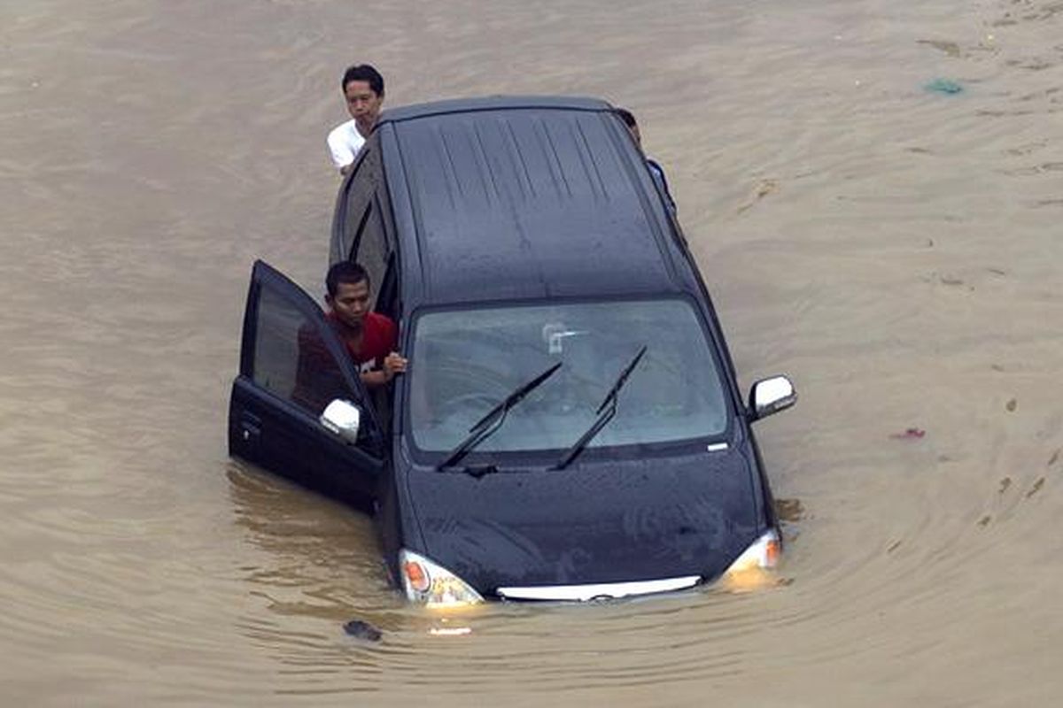 Caption : Luapan Kali Ciliwung memutus jalur kendaraan di Jalan KH Abdullah Syafiie, Tebet, Jakarta Selatan, Senin (13/1/2014). Luapan kali mulai menggenangi permukiman dan memutus jalan sejak Senin dini hari. KOMPAS/AGUS SUSANTO 