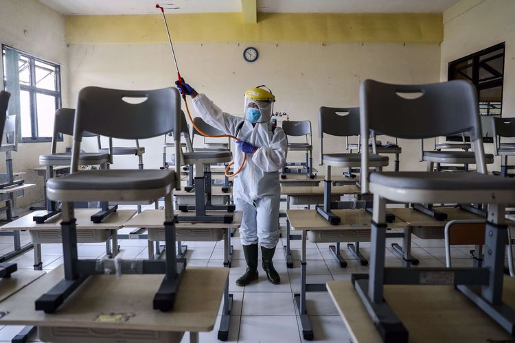 Petugas Palang Merah Indonesia (PMI) Jakarta Pusat menyemprotkan cairan disinfektan di sekolah SMKN 2, Jalan Batu, Gambir, Jakarta Pusat, Selasa (23/6/2020). Palang Merah Indonesia mengencarkan penyemprotan cairan disinfektan di sekolah di tengah masa penerimaan peserta didik baru (PPDB) tahun ajaran 2020/2021.