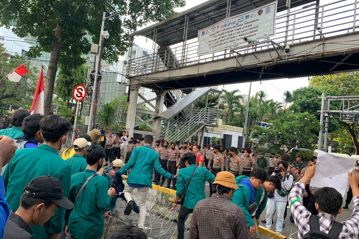 Peserta unjuk rasa tolak kenaikan harga BBM memaksa maju ke kawasan Istana Merdeka dengan menerobos kawat berduri yang terpasang di Jalan Medan Merdeka Barat, Jakarta Pusat, Senin (12/9/2022).