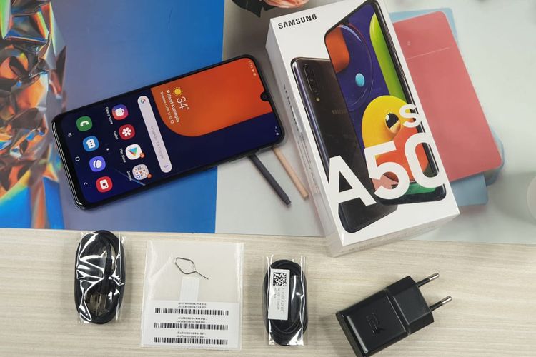 Isi kotak kemasan Galaxy A50s yang terdiri dari kepala charger fast charging 15W, kabel USB C, earphone dengan colokan jack audio 3,5mm, ejektor, dan nomor IMEI.