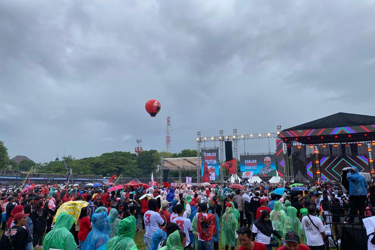 Ratusan massa berkumpul saat hujan mengguyur dalam kampanye akbar pasangan calon nomor urut 3, Ganjar Pranowo-Mahfud MD di Benteng Vastenburg, Solo, Jawa Tengah, Sabtu (10/2/2024). 