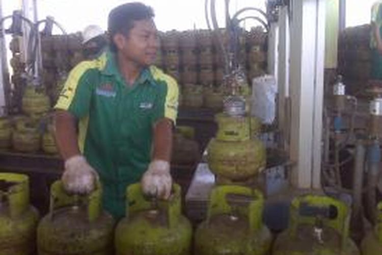 Seorang Karyawan SPBE Indo Gas Hiswana Pratama, mengisi gas elpiji ke dalam tabung ukuran tiga kilogram, Senin (22/7/2013)