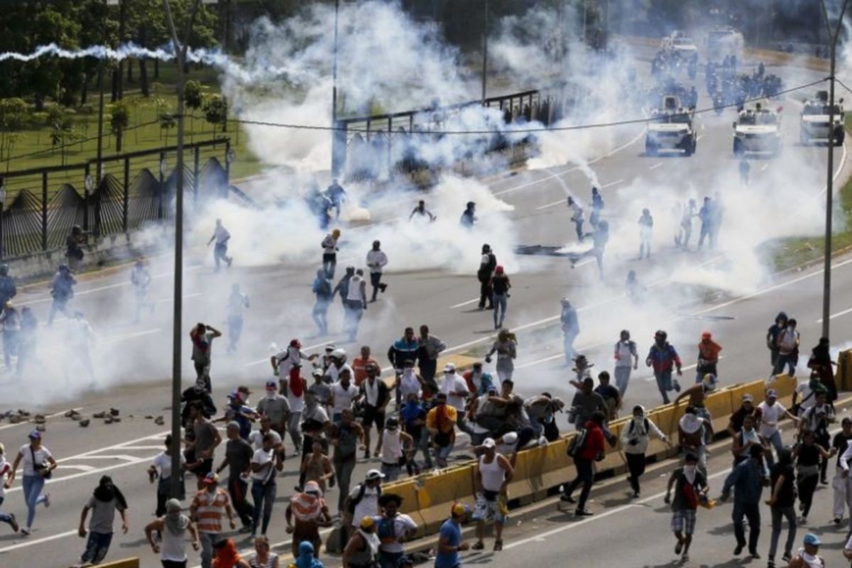 Pasukan keamanan menembakkan gas air mata ke arah demonstran anti-pemerintah di Caracas, Venezuela, Rabu (19/4/2017). Awalnya unjuk rasa damai, lalu rusuh sehingga tiga orang tewas hari itu.
