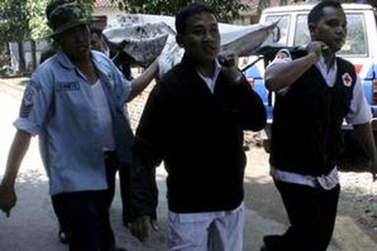 Petugas mengevakuasi korban tewas jatuhnya Pesawat Hercules jenis C-130 dengan nomor registrasi A1325 di Desa Geplak, Kecamatan Karas, Kabupaten Magetan, Jawa Timur, Rabu (20/5).