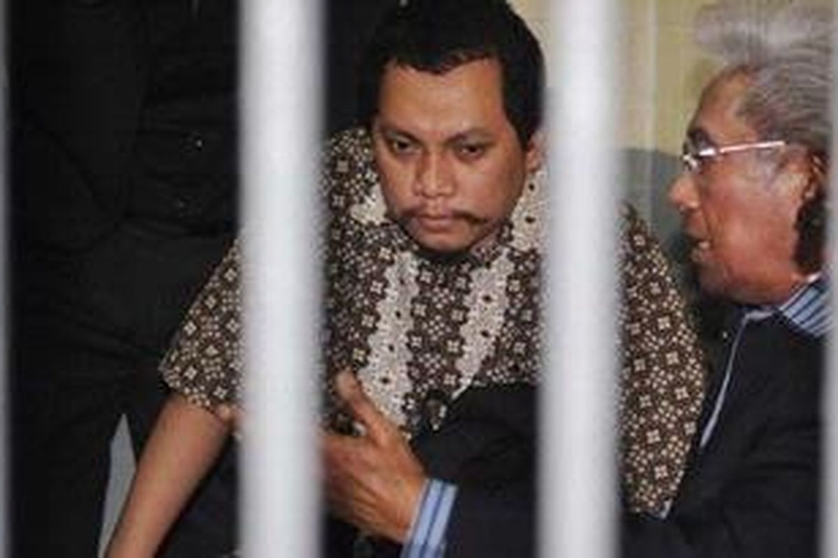 Indonesian tax officer Gayus Tambunan (C) confers with his lawyers at the court detention cell in Jakarta on January 19, 2011. Tambunan, 31, who admited to causing hundreds of millions of dollars in state losses, was sentenced by the court to seven years in jail, well short of the 20 years sought by prosecutors.