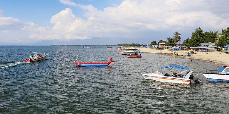 Wisatawan menikmati Danau Toba di Pantai Pasir Putih Lumban Bulbul, Kecamatan Balige, Kabupaten Toba Samosir, Sumatera Utara, Jumat (9/6/2017).