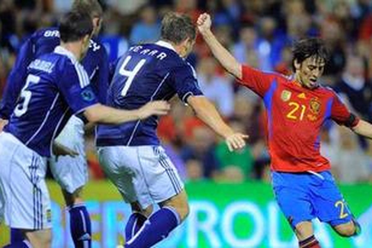 Gelandang Spanyol, David Silva (kanan), melepaskan tembakan yang berujung gol ke gawang Skotlandia, pada laga fase grup kualifikasi Piala Eropa 2012, Selasa (11/10/2011). 