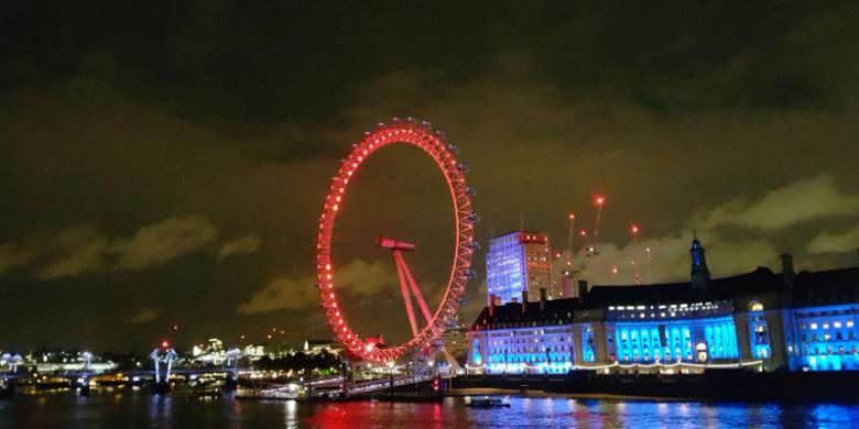 London Eye di tepi Sungai Thames saat malam. Posisinya berseberangan dengan Big Ben yang menjadi salah satu ikon London.
