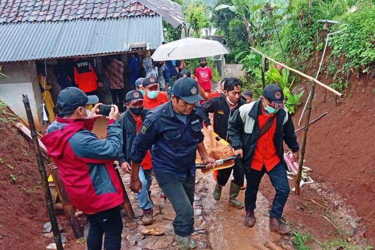 Personel BPBD Cianjur, Jawa Barat, sedang membawa jenazah salah satu korban tanah longsor untuk dimakamkan, Minggu (6/2/2022).
