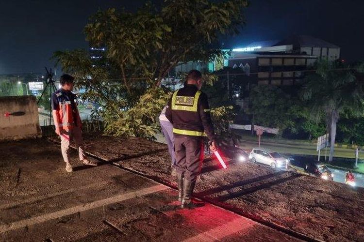 Satlantas Polres Gresik saat melakukan olah TKP kecelakaan mobil terjun dari ujung tol Krian-Gresik, Sabtu (5/4/2025) malam. Pengemudi dan penumpang mobil selamat dalam insiden ini. 