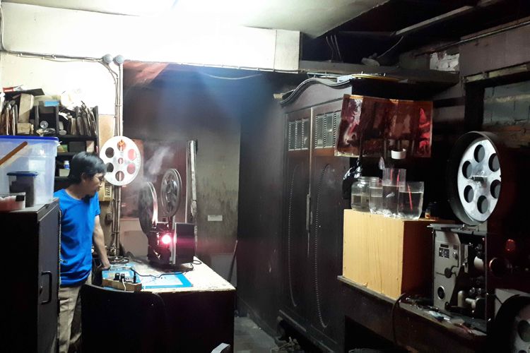 Danny Mulyana saat memutar film menggunakan proyektor analog di kamarnya di samping ruangan Grand 1, Bioskop Mulia Agung, Senen, Jakarta Pusat. Foto diambil Kamis (14/3/2019).