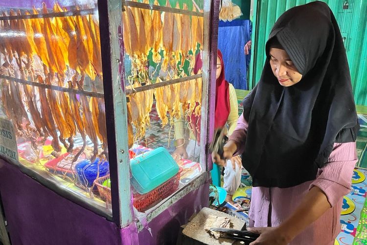 Ipit (35), pedagang sotong pangkong di Jalan Merdeka Barat, Kota Pontianak, Kalimantan Barat (Kalbar) sedang menyiapkan pesanan salah seorang pengunjung penikmat sotong pangkong, Kamis (21/3/2024).