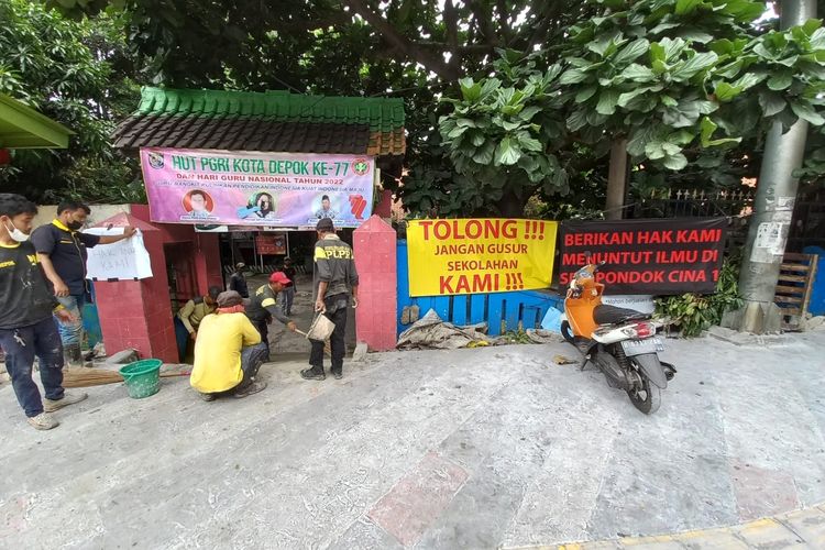 Dikeluhkan orangtua siswa lantaran revitalisasi trotoar Margonda lebih tinggi daripada permukaan sekolah, petugas Dinas PUPR Kota Depok tengah membuat akses jalan menuju SDN Pondok Cina 1, Beji, Depok pada Rabu (9/11/2022).