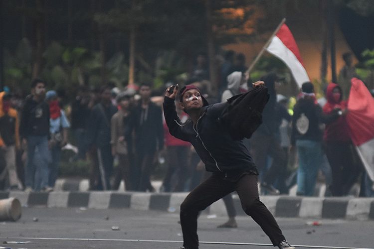 Pelajar melempari polisi dengan batu saat melakukan aksi unjuk rasa di kawasan Pejompongan, Jakarta, Rabu (25/9/2019). Demo yang melibatkan pelajar dari berbagai tingkatan menengah ke atas dan diwarnai kericuhan pada Rabu kemarin masih terkait aksi penolakan UU KPK dan RKUHP yang telah bergulir di sejumlah daerah sejak awal pekan.