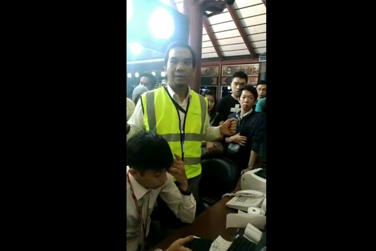 Salah satu petugas dari Sriwijaya Air saat dikerumuni calon penumpang di Bandara Internasional Soekarno Hatta meminta kejelasan terkait keberangkatan menuju Pontianak, Kamis (7/6/2018) malam.