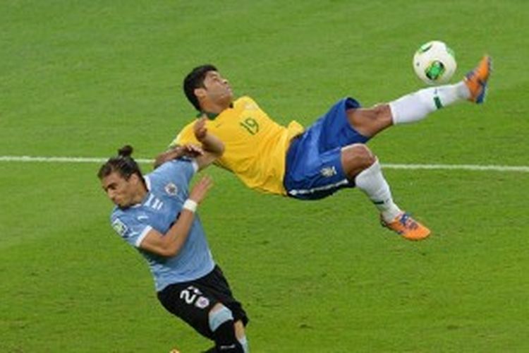 Striker Brasil, Hulk (kanan), mencoba melakukan tendangan salto, sementara bek Uruguay, Martin Caceres, mencoba menghalanginya. Pada laga semifinal Piala Konfederasi 2013, Rabu atau Kamis (27/6/2013) dini hari WIB itu, Brasil akhirnya menang 2-1 berkat gol Fred dan Paulinho. Sedangkan gol Uruguay dicetak Edinson Cavani.