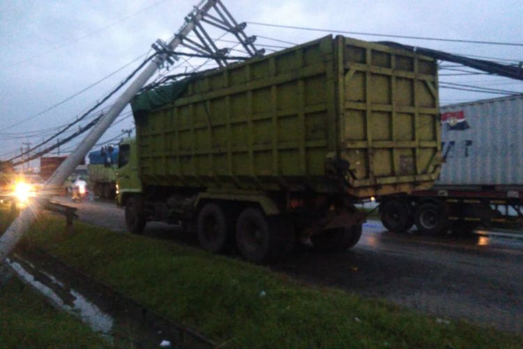 Hujan deras bercampur angin kencang di Kecamatan Manyar, Gresik, menyebabkan tiang listrik roboh dan menimpa beberapa kendaraan serta pengendara motor, Senin (21/2/2022).