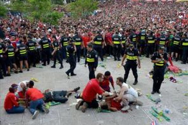 Suporter Kosta Rika tergeletak akibat luka tusuk di antara kerumunan suporter yang menyaksikan laga perempat final antara Kosta Rika dan Belanda, Sabtu (5/7/2014). 